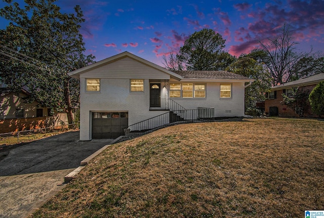 view of front of home featuring a garage, a front yard, brick siding, and driveway