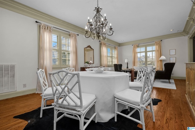 dining room featuring a wealth of natural light, wood finished floors, visible vents, and crown molding