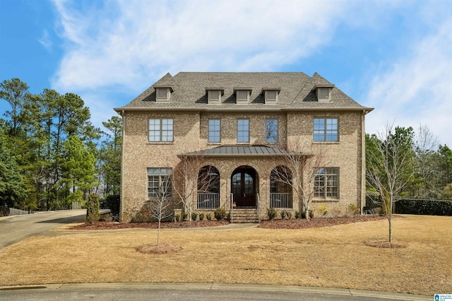 view of front of house featuring a shingled roof and covered porch