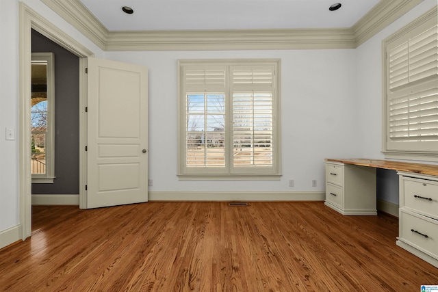 unfurnished office featuring crown molding, baseboards, and wood finished floors