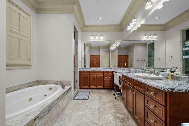 bathroom with vanity, a tub with jets, and ornamental molding