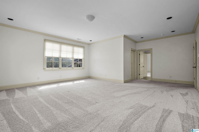 empty room featuring ornamental molding, carpet, and baseboards