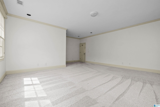 carpeted spare room featuring visible vents, crown molding, and baseboards