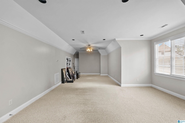 unfurnished room with light colored carpet, crown molding, visible vents, and baseboards