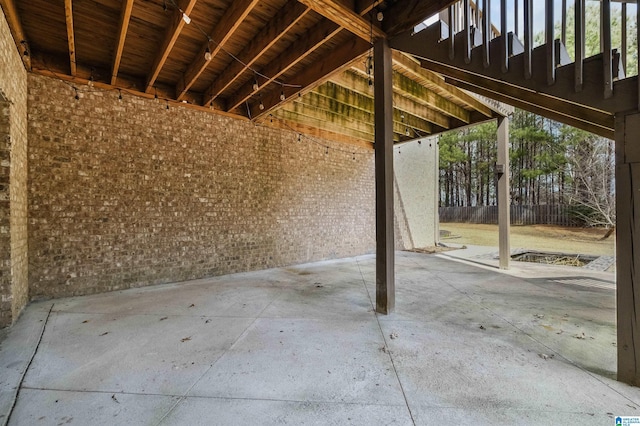 exterior space with brick wall and unfinished concrete flooring