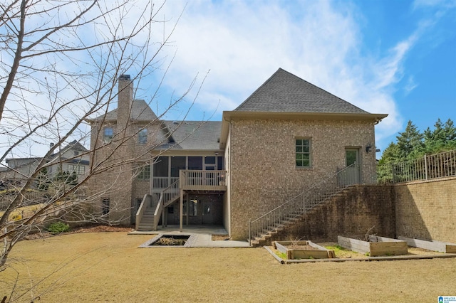 back of property with a garden, a lawn, a sunroom, stairway, and a patio area