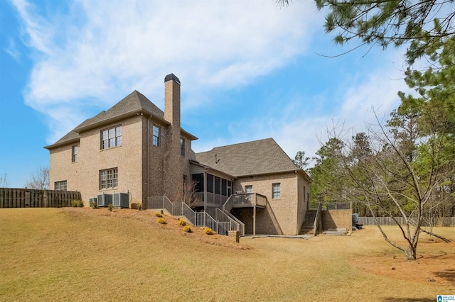 rear view of property featuring a chimney, central air condition unit, a sunroom, fence, and stairs