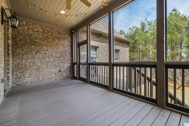 unfurnished sunroom featuring ceiling fan