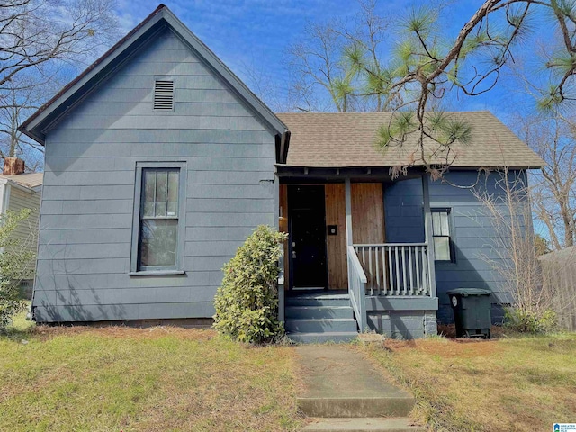 single story home with a front lawn and a shingled roof