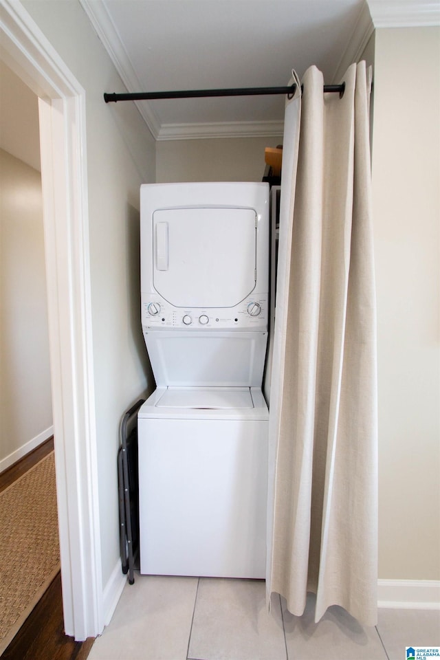 laundry room with stacked washing maching and dryer, baseboards, laundry area, and ornamental molding