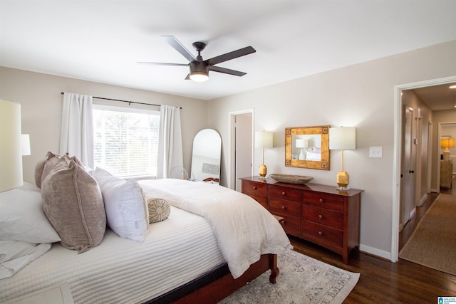 bedroom with ceiling fan, baseboards, and dark wood-style flooring