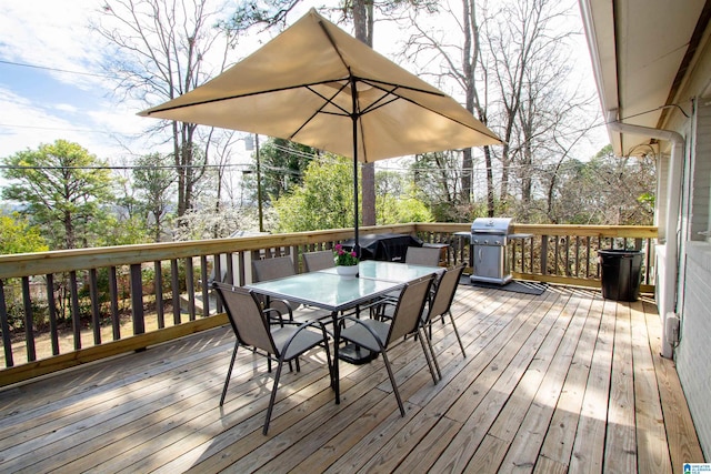 wooden terrace with area for grilling and outdoor dining space