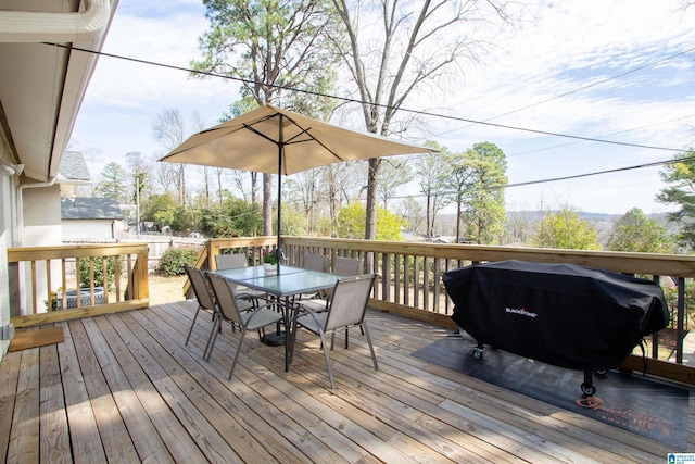 deck with outdoor dining area and grilling area