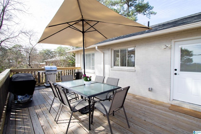 wooden terrace with outdoor dining area and grilling area