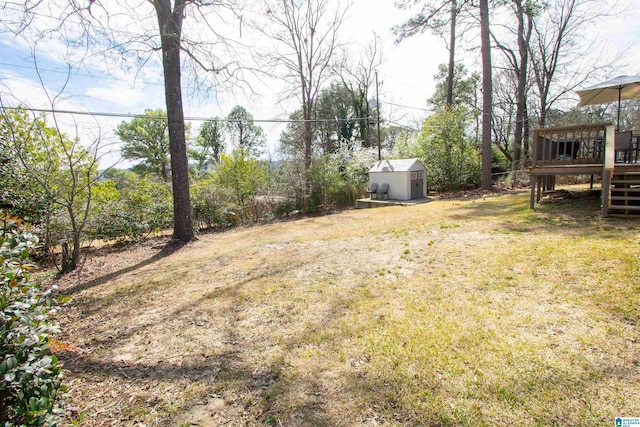 view of yard with stairs, an outbuilding, a deck, and a storage unit