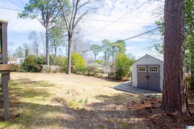 view of yard with a storage shed, fence, and an outbuilding