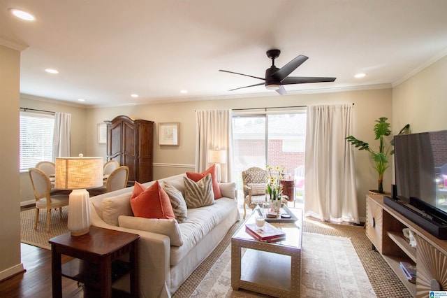 living room featuring a wealth of natural light, crown molding, and recessed lighting