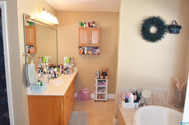 bathroom featuring baseboards, vanity, a bath, and tile patterned floors