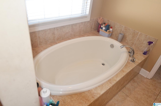 bathroom with tile patterned flooring and a bath