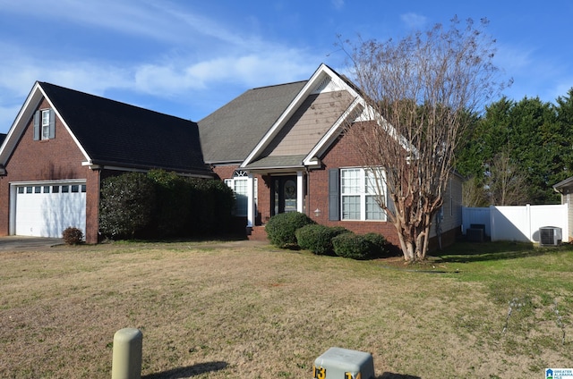 view of front of home with brick siding, fence, a front lawn, and central AC unit