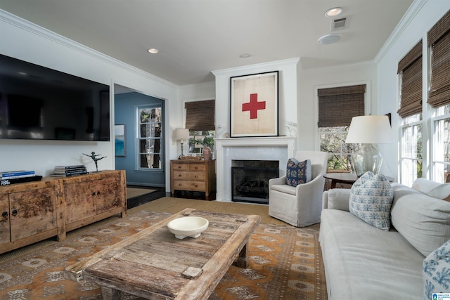 living area with recessed lighting, visible vents, a fireplace, and crown molding