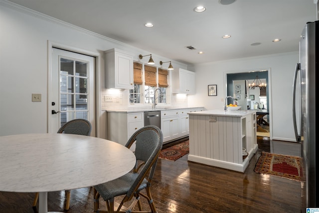 kitchen with visible vents, a center island with sink, stainless steel appliances, crown molding, and dark wood-style flooring