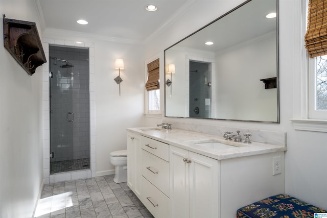 bathroom featuring a shower stall, toilet, double vanity, ornamental molding, and a sink