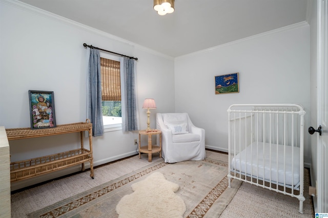 bedroom featuring baseboards, a nursery area, wood finished floors, and crown molding