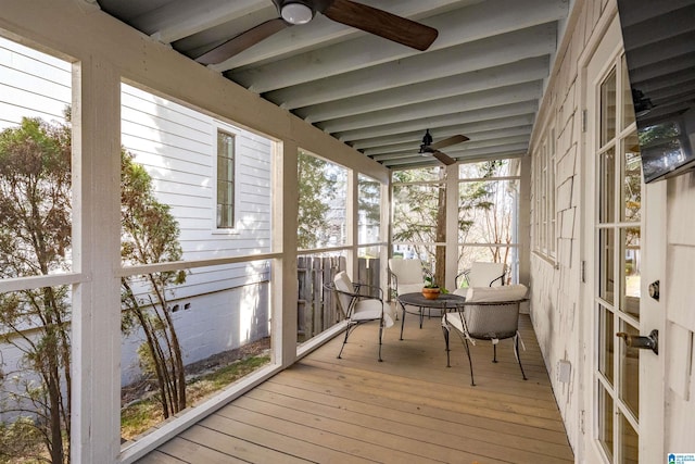 sunroom featuring beamed ceiling and a ceiling fan