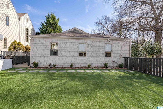 view of home's exterior with a lawn and fence