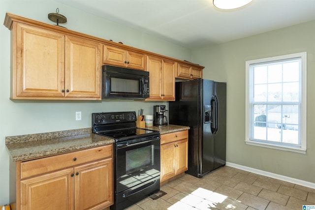 kitchen with black appliances, baseboards, and dark stone countertops