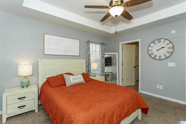 bedroom featuring carpet flooring, a raised ceiling, a ceiling fan, and baseboards