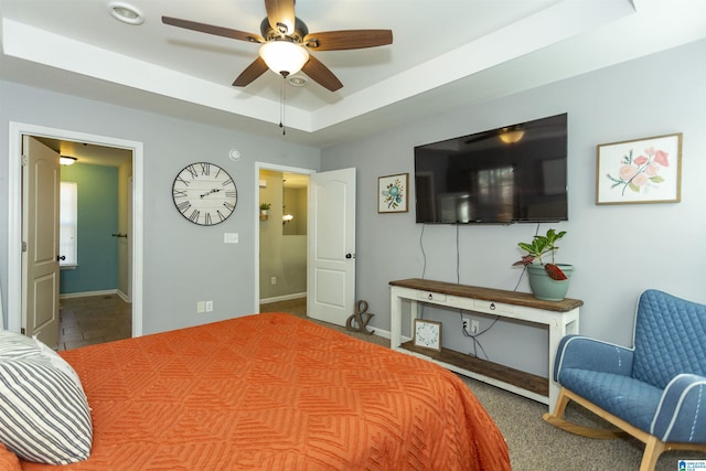 bedroom with a raised ceiling and baseboards