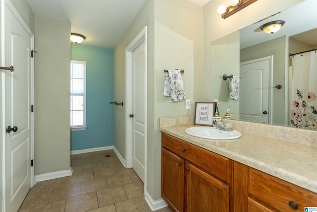 bathroom with tile patterned floors, baseboards, and vanity