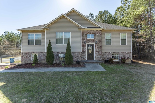 bi-level home with brick siding and a front lawn