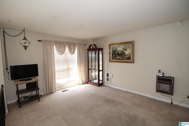 living room featuring light carpet, baseboards, visible vents, and heating unit