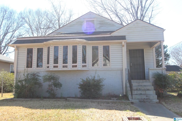 bungalow featuring brick siding and a front lawn