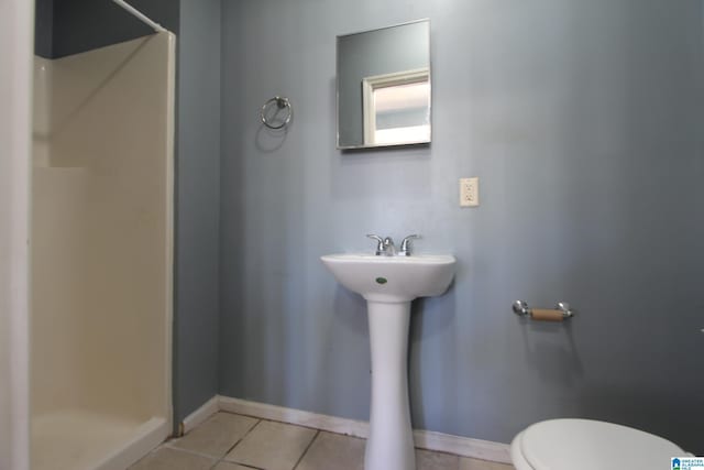 full bath featuring baseboards, a stall shower, toilet, and tile patterned floors