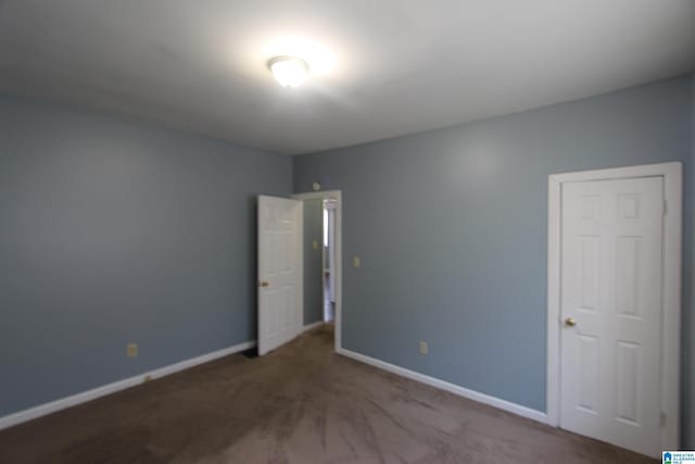 carpeted spare room with baseboards