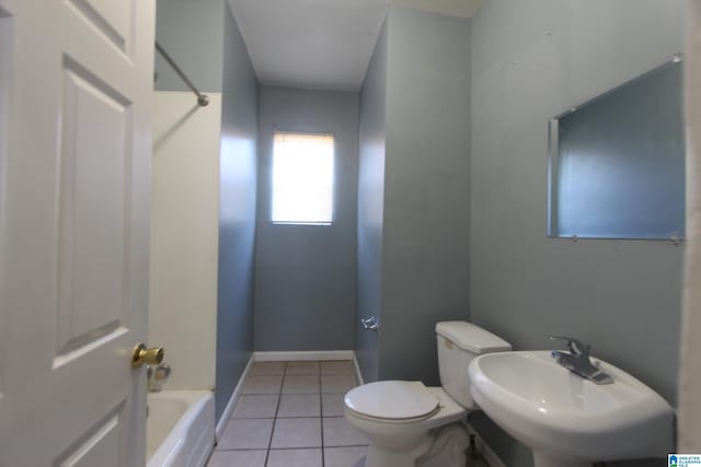 bathroom with toilet, a sink, baseboards,  shower combination, and tile patterned floors