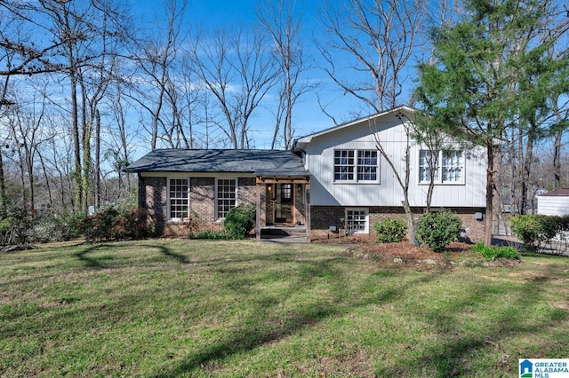 tri-level home with brick siding and a front lawn