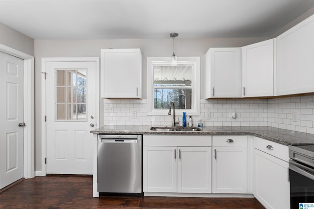 kitchen with tasteful backsplash, stainless steel dishwasher, white cabinets, a sink, and dark stone counters