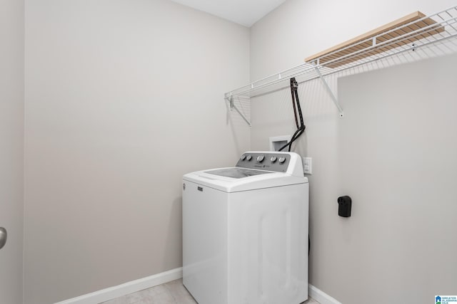 clothes washing area featuring laundry area, washer / clothes dryer, and baseboards