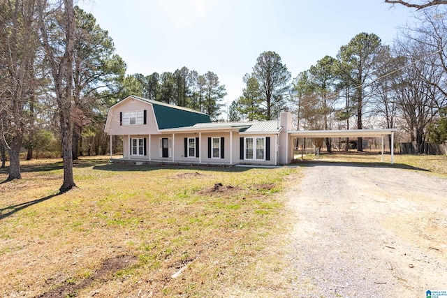 view of front of house featuring dirt driveway, a carport, a front lawn, and metal roof