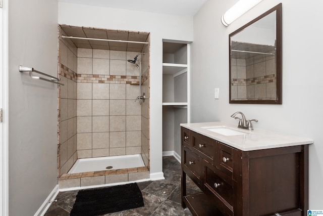 full bathroom featuring a stall shower, baseboards, and vanity