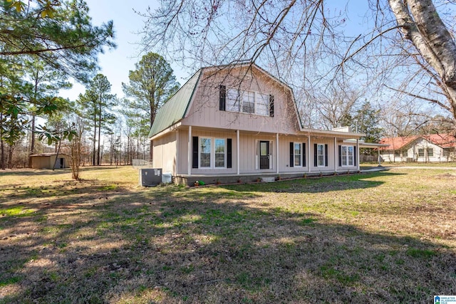 rear view of house featuring metal roof, a lawn, and a gambrel roof