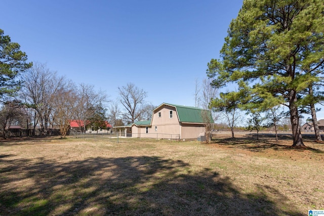 view of yard featuring an outbuilding, a barn, and fence