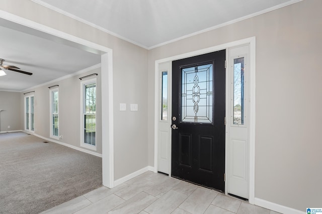 foyer featuring light carpet, ceiling fan, baseboards, and crown molding