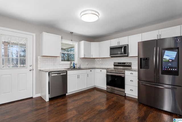 kitchen featuring light stone counters, stainless steel appliances, and dark wood-style flooring