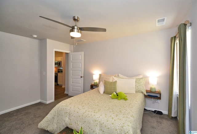 bedroom with dark colored carpet, visible vents, ceiling fan, and baseboards